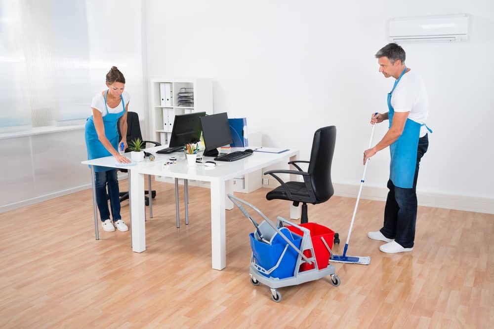 two cleaners clean vinyl chairs in office room
