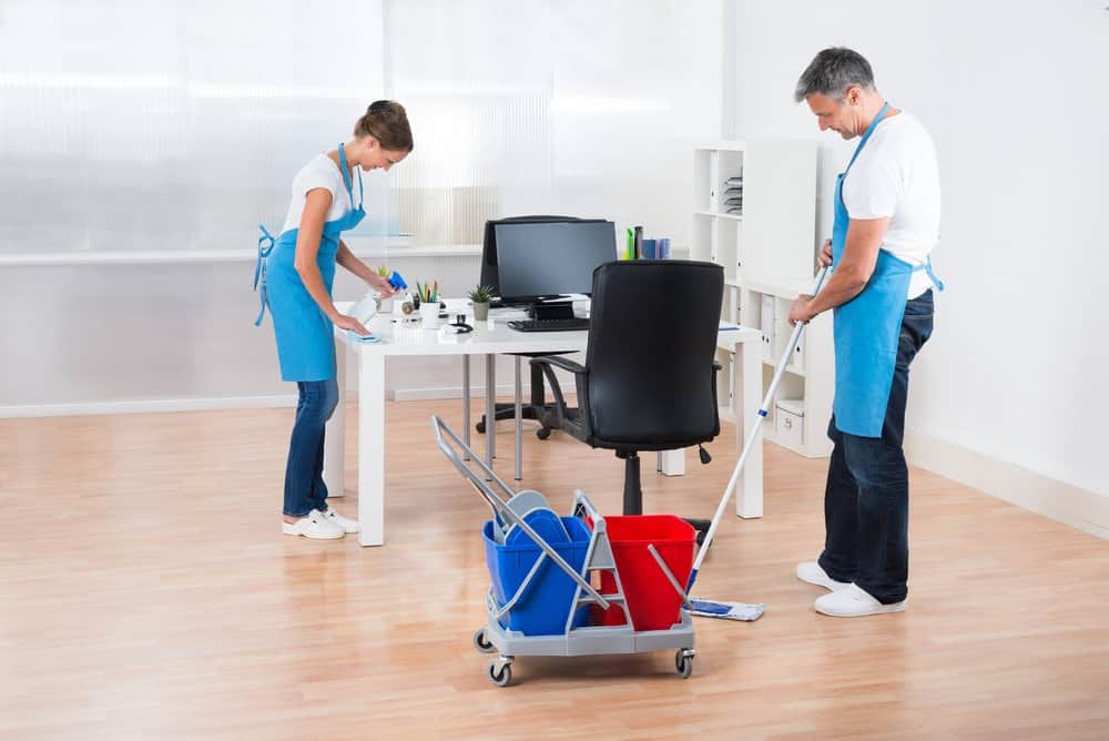 two janitors cleaning office chair