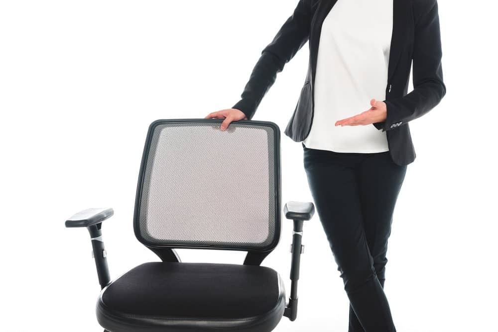 woman standing near office chair