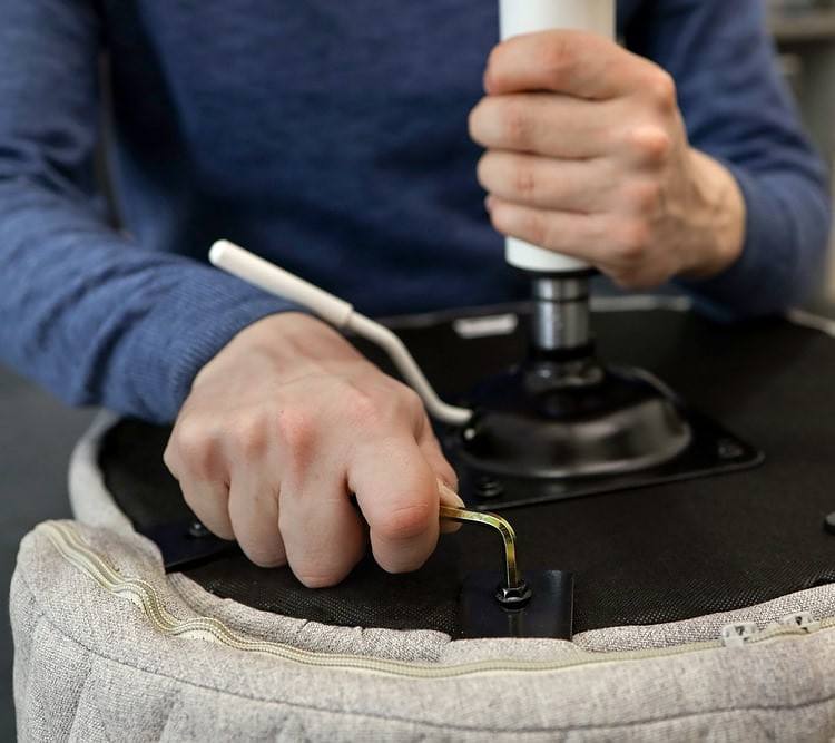 A man fixes an office chair cylinder