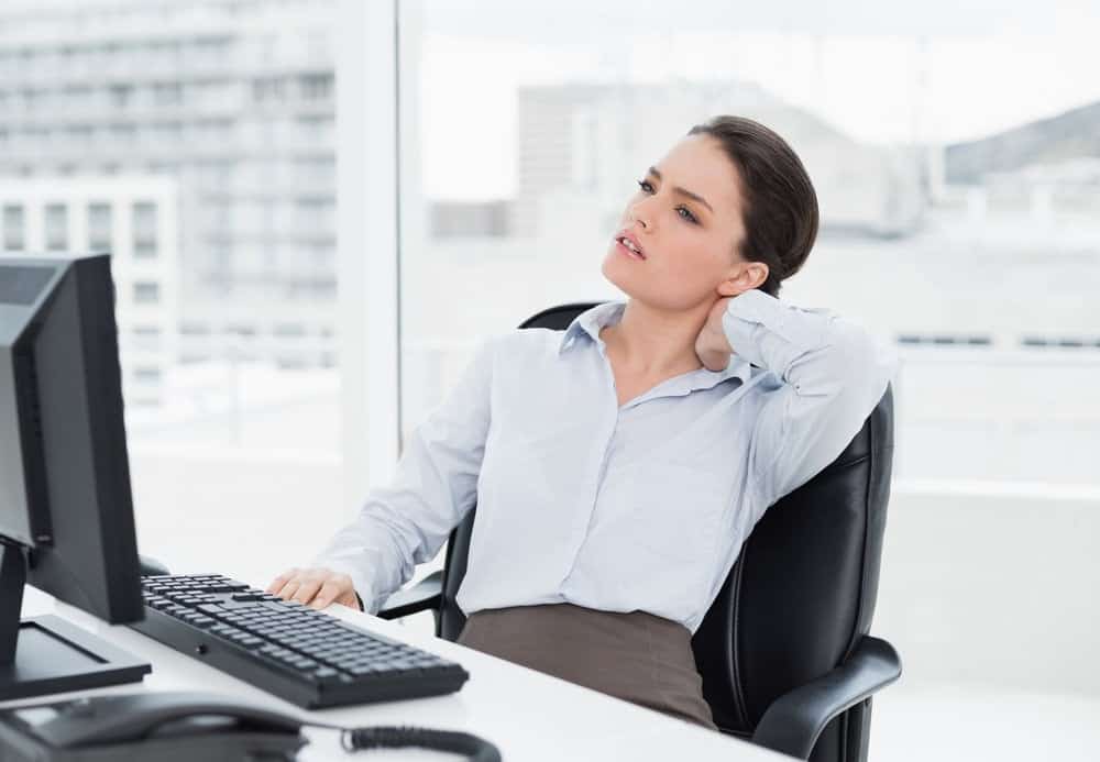 Businesswoman with neck pain sitting on office chair
