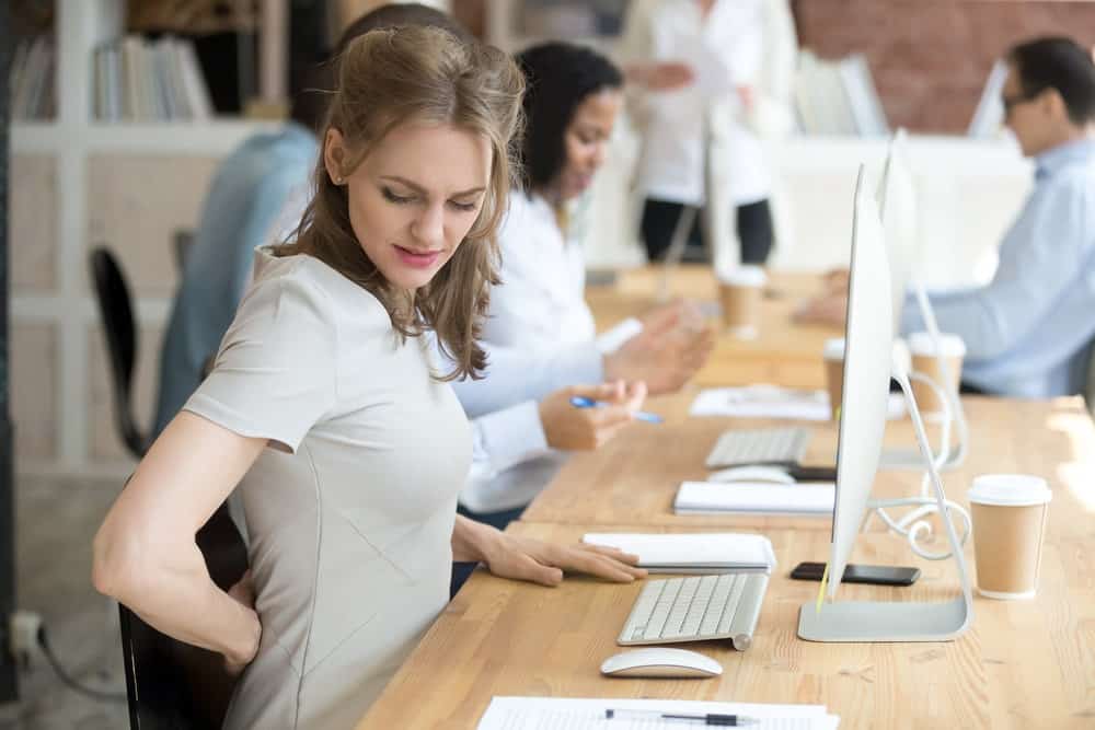 Female suffering from low back pain at work