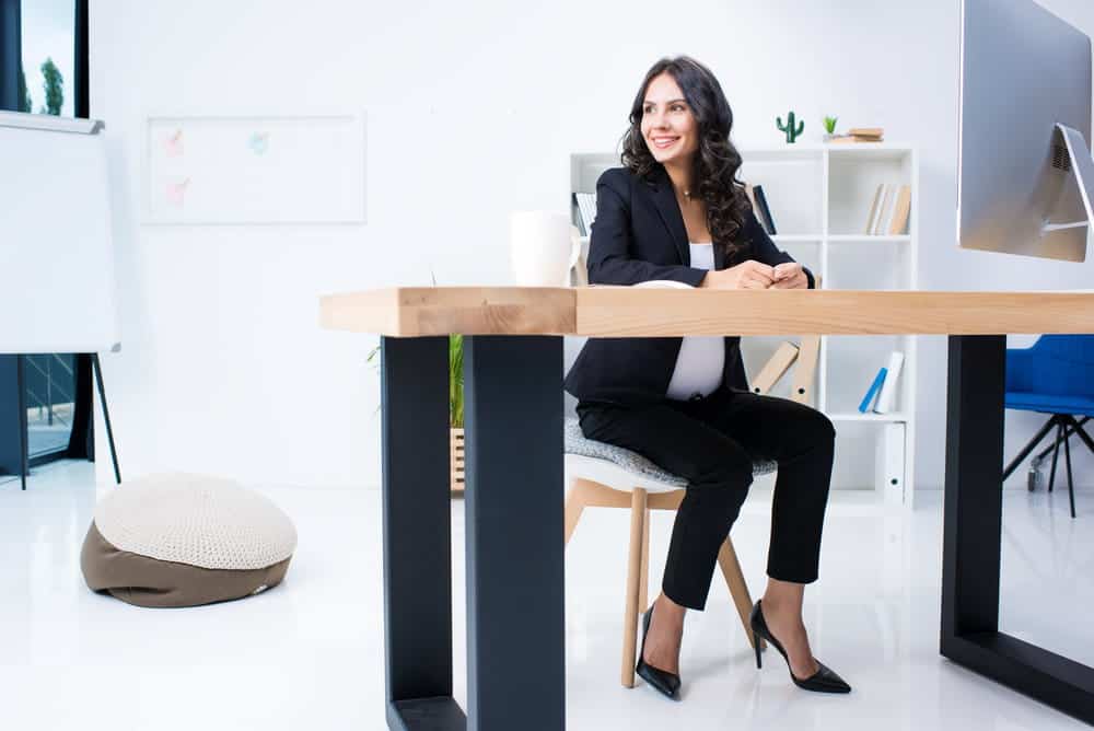 Pregnant businesswoman sitting comfortably in office chair at workplace