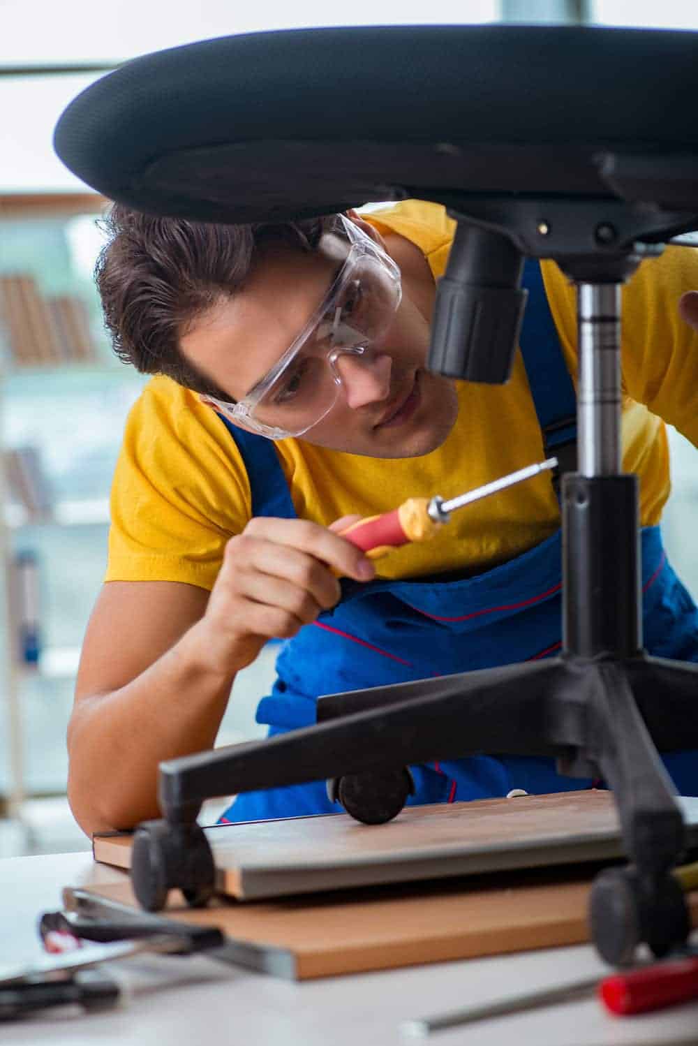 man putting all office chair parts together