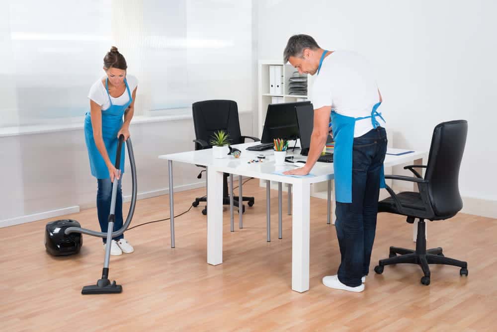 two janitors are cleaning the leather office chairs