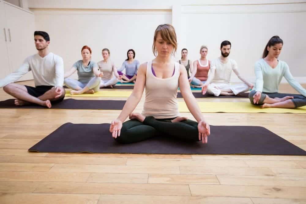 many people sitting cross-legged in the Lotus Pose