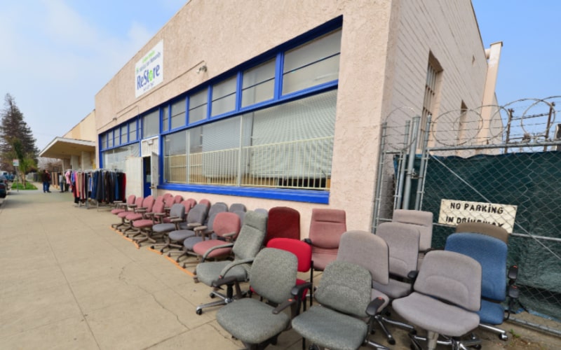 donated old chairs are exhibited in front of the Habitat for Humanity's store