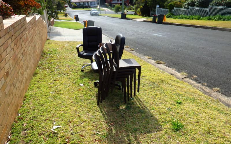 old chairs are left on the side walk path