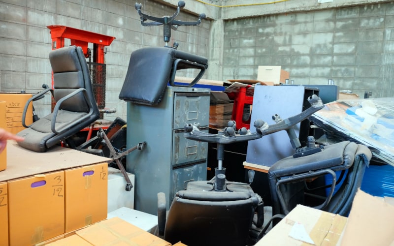 old office chairs and other broken furniture are disposed as trash