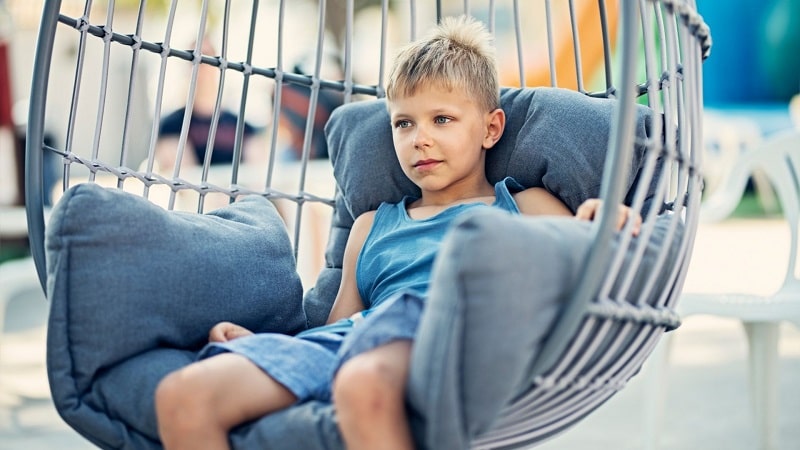 Boy relax sitting in an egg chair