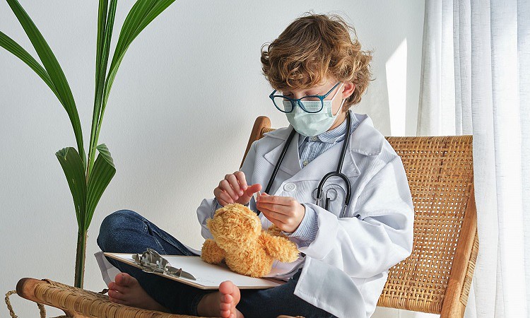 Child sitting with legs on chair and playing toy