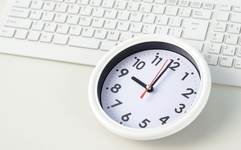 Computer keyboard with clock on table