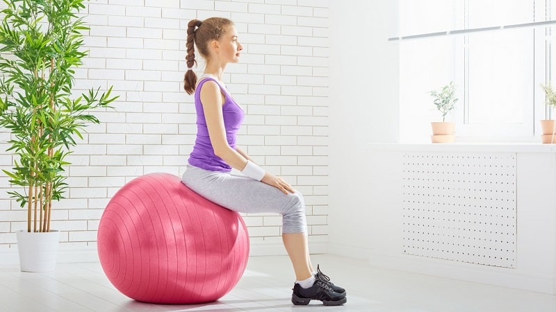 Girl sitting straightly on a swiss ball