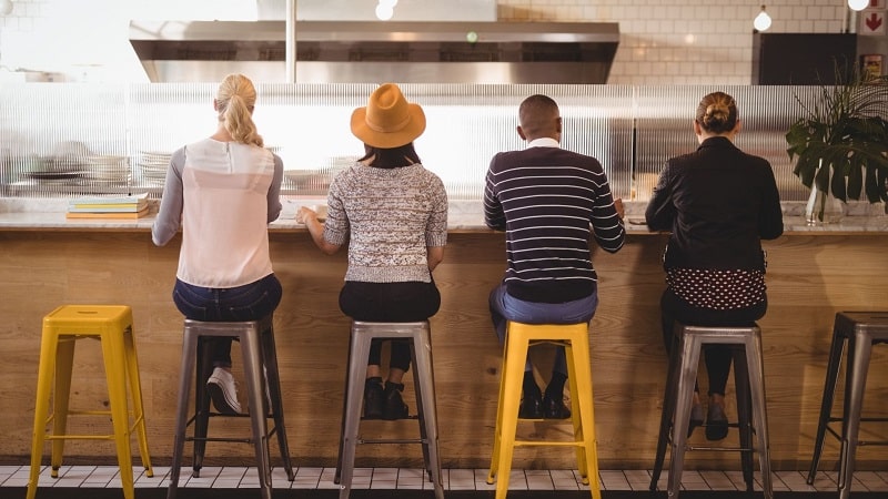 Rear view of customers sitting on stools at a counter