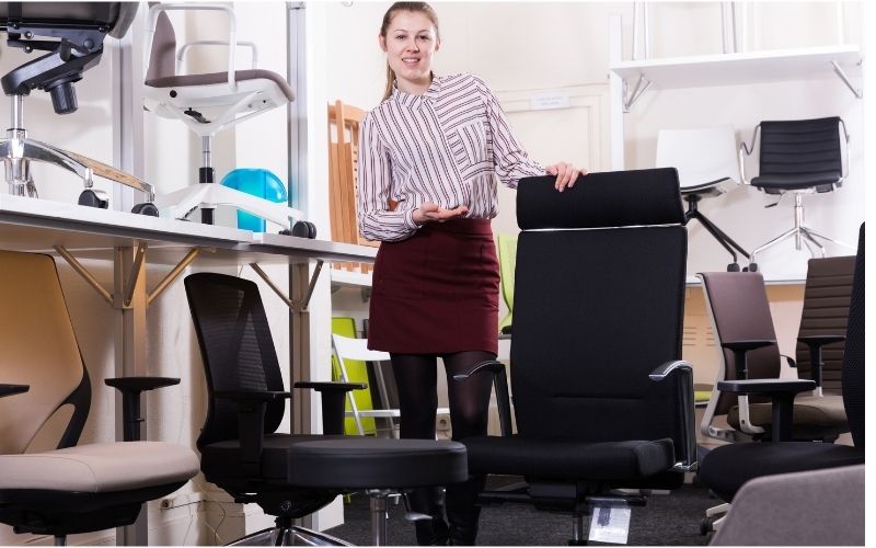 Woman seller at furniture store propose an office chair