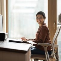 a smiling girl sits on an office chair