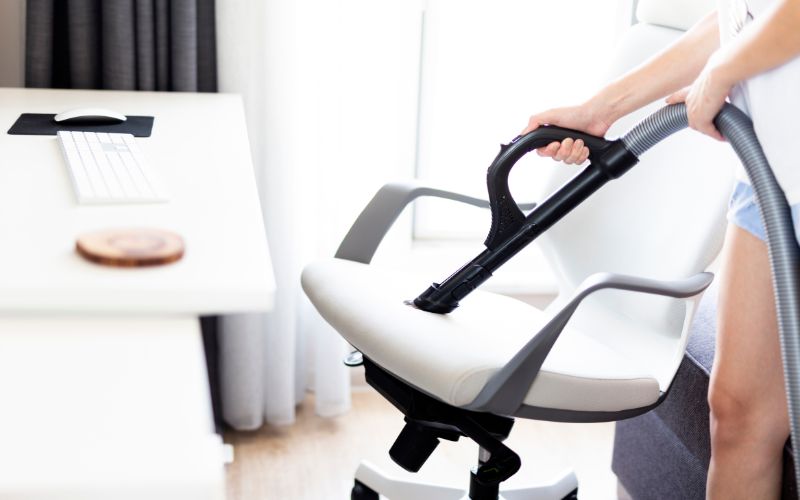 cleaning the white steelcase chair with the vacuum