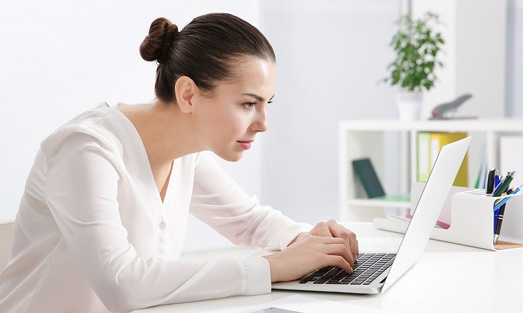 woman in slouching posture while working with laptop