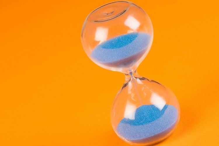 Blue sand clock on orange background