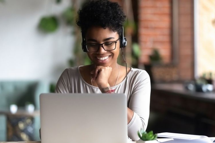 Girl smiling while working on laptop