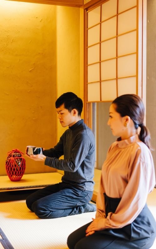Man and woman sitting in seiza style in tea ceremony