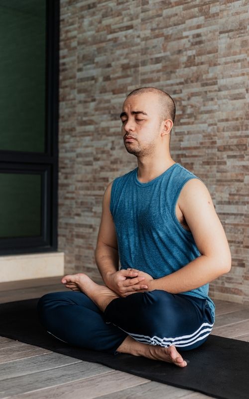 Man sitting in half lotus pose to meditate