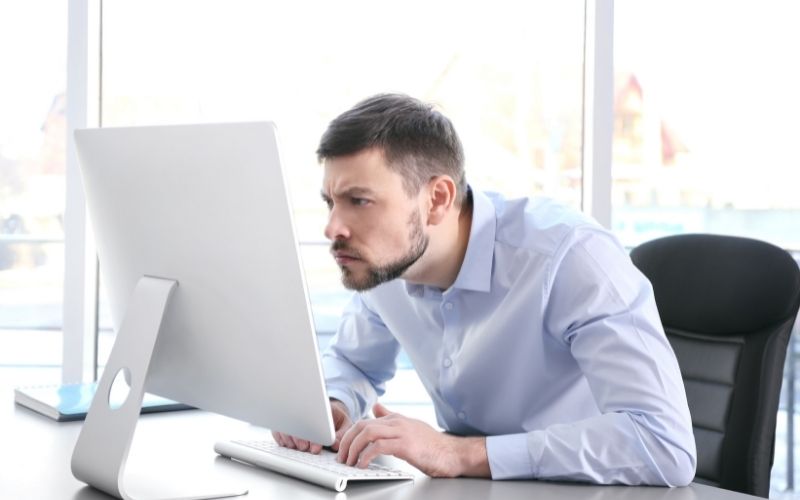 Man sitting in slump posture working with computer