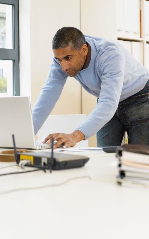 Man using laptop on short desk
