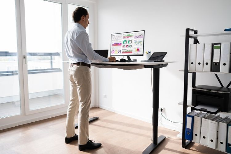Man working with computer at a standing desk
