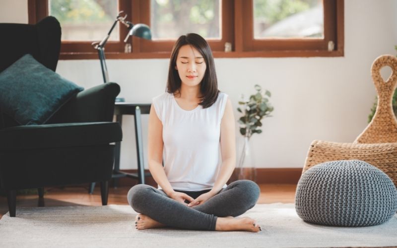 Woman practicing meditation at home
