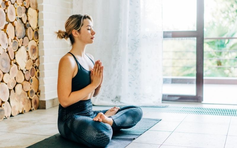 Woman sitting in lotus position to meditate
