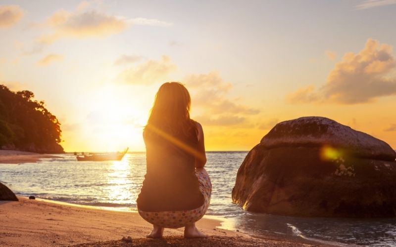 Woman squat sitting on the beach