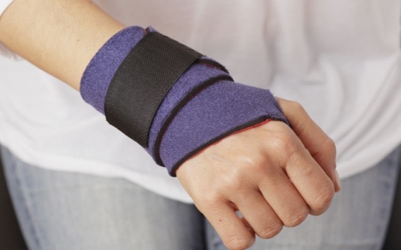 Woman wears a wrist splint to support wrist while working