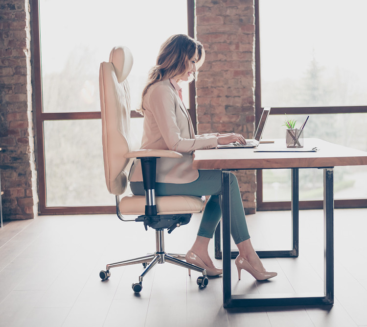 a girl sits on an office chair in her home office