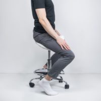 a man sits on a stool with a straight back