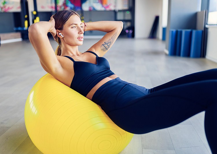 Woman crunching on exercise ball