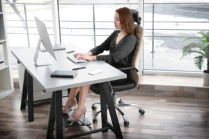 A woman sitting with footrest in her office