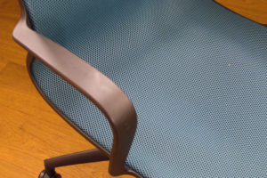 An armrest on an orange office chair