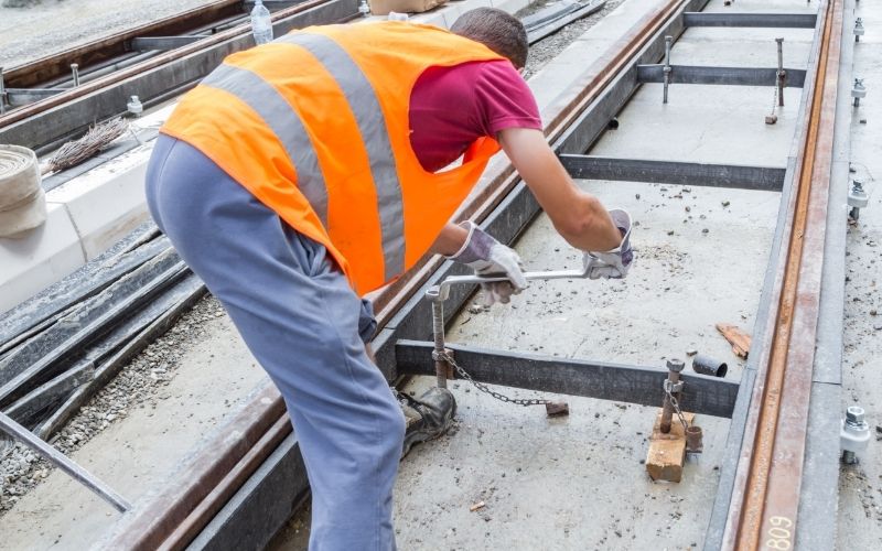 Worker at construction site works in bad posture