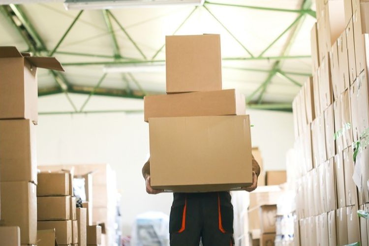 Worker lifting heavy boxes