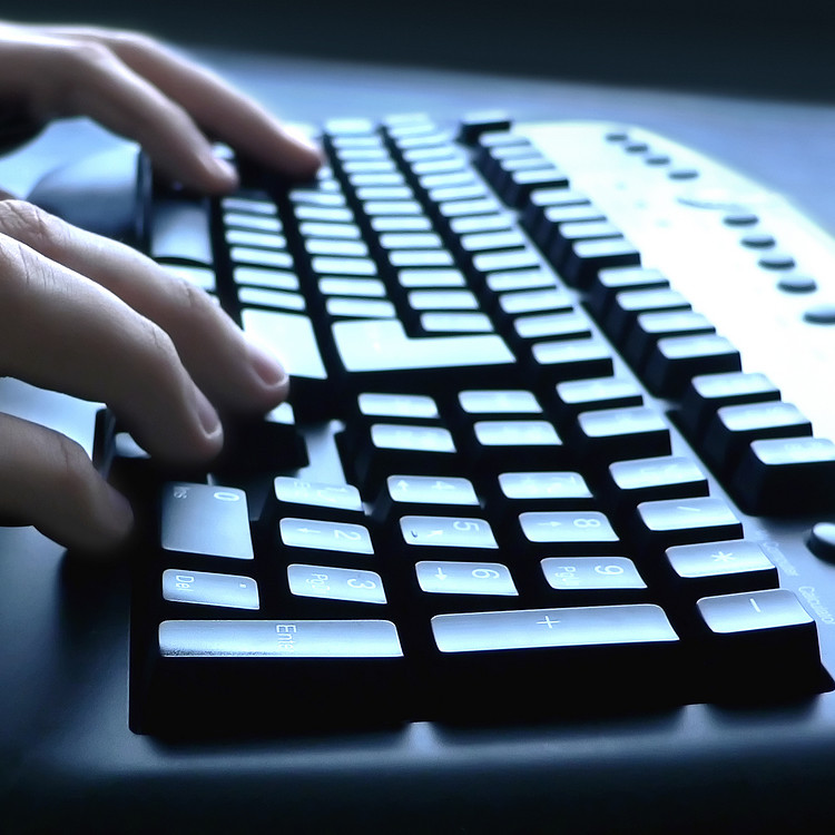 A person typing on black ergonomic keyboard