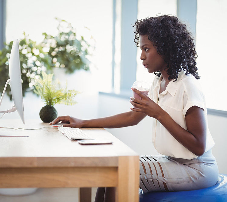 A girl using exercise ball as office chair