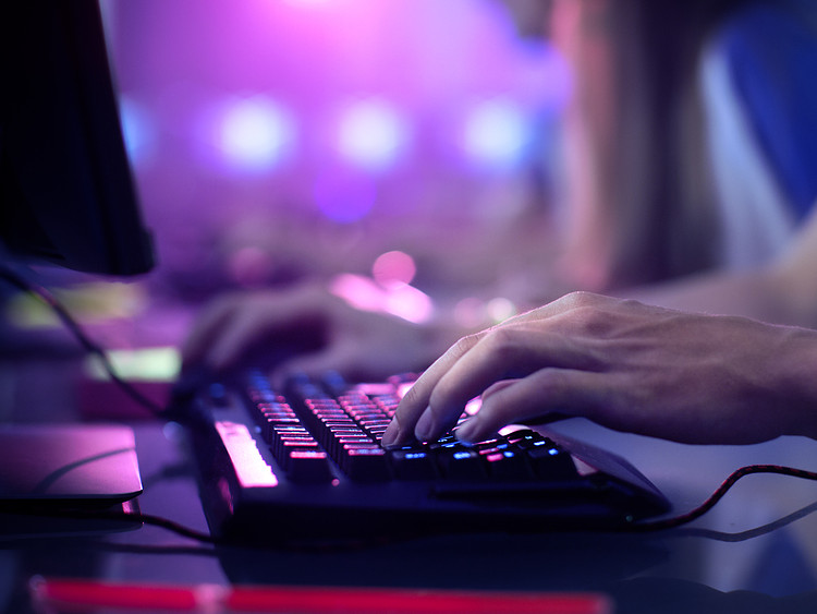 A person playing game with gaming keyboard