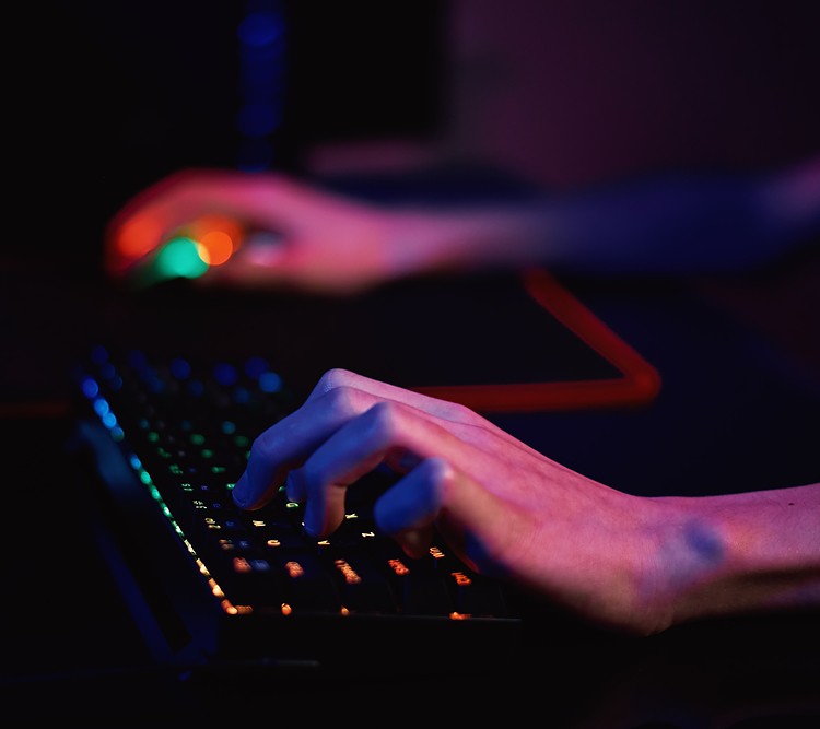 A person using ergonomic keyboard to play game