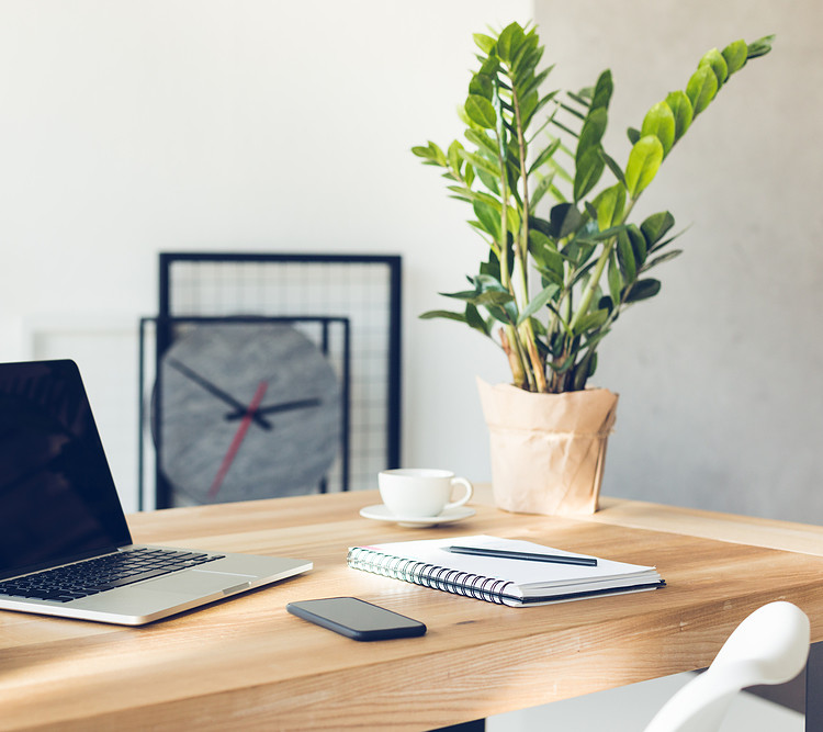 A wooden desk with office supplies