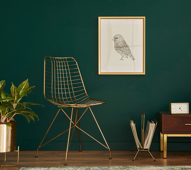 An armless chair in a green living room