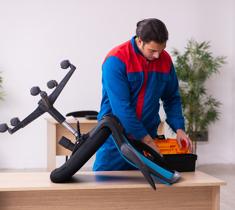 A man is repairing a broken office chair