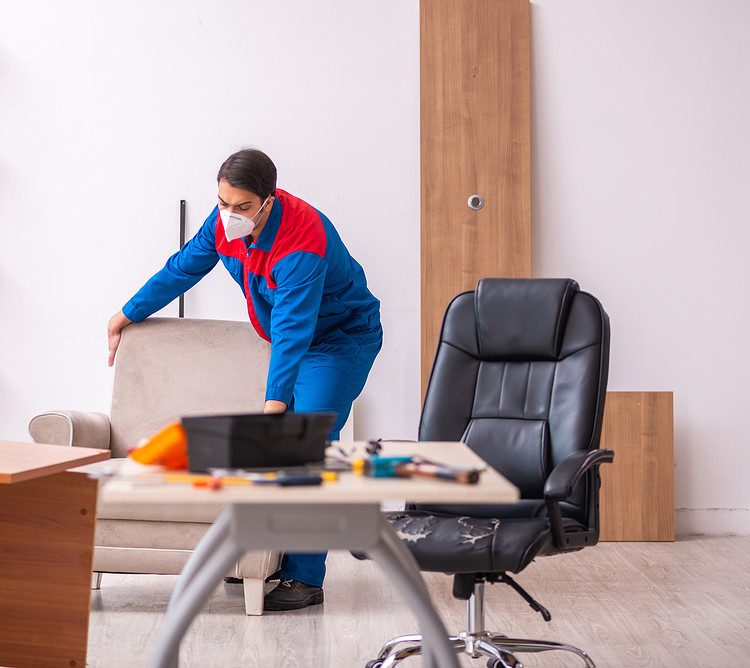 A person gets ready to repair an office chair