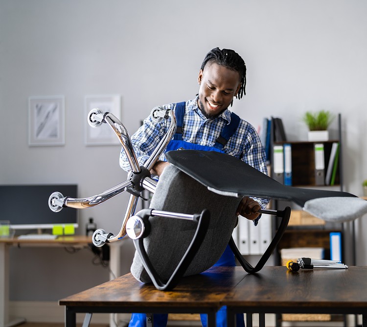 A person happily repairing an office chair