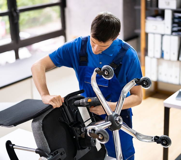 A Person Is Reparing A Broken Office Chair 